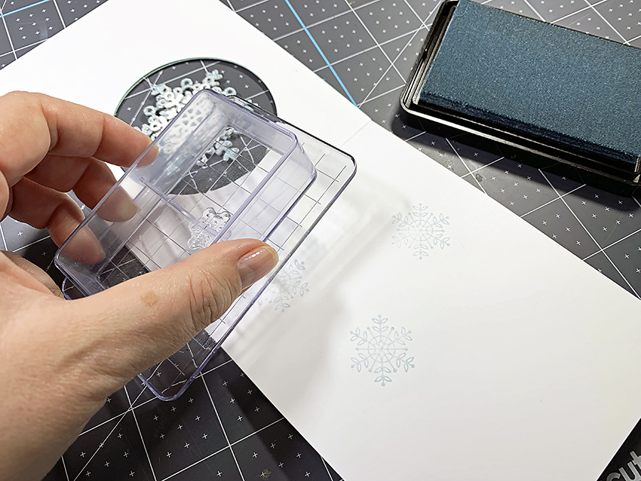 Stamping the snowflakes on the inside of the card.
